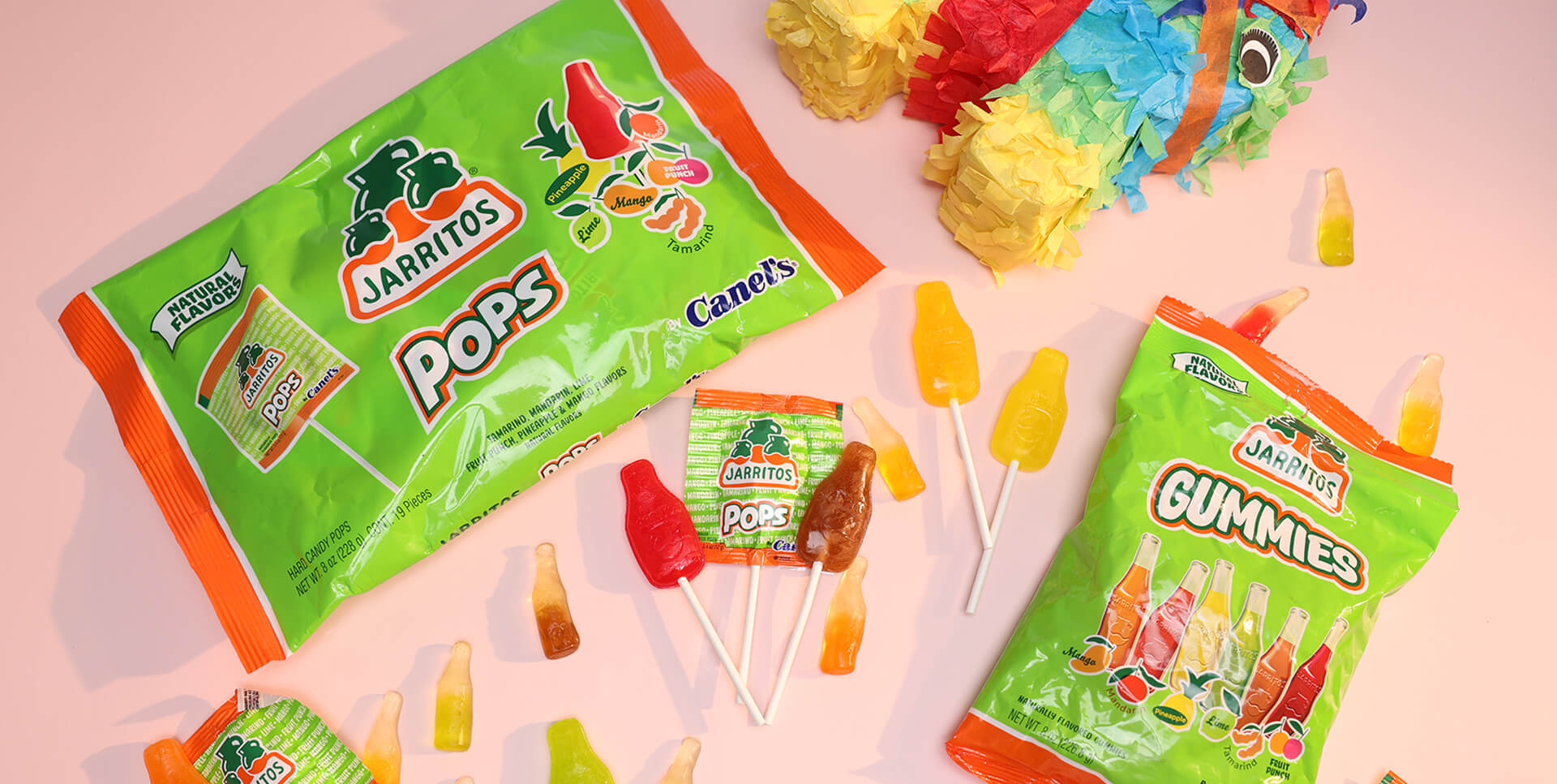 Jarritos and Canel’s collaborative candy packs featuring Pops and Gummies in assorted soda-inspired flavors, surrounded by bottle-shaped candies and a colorful piñata—celebrating Mexican tradition with playful sweets and bold flavor.