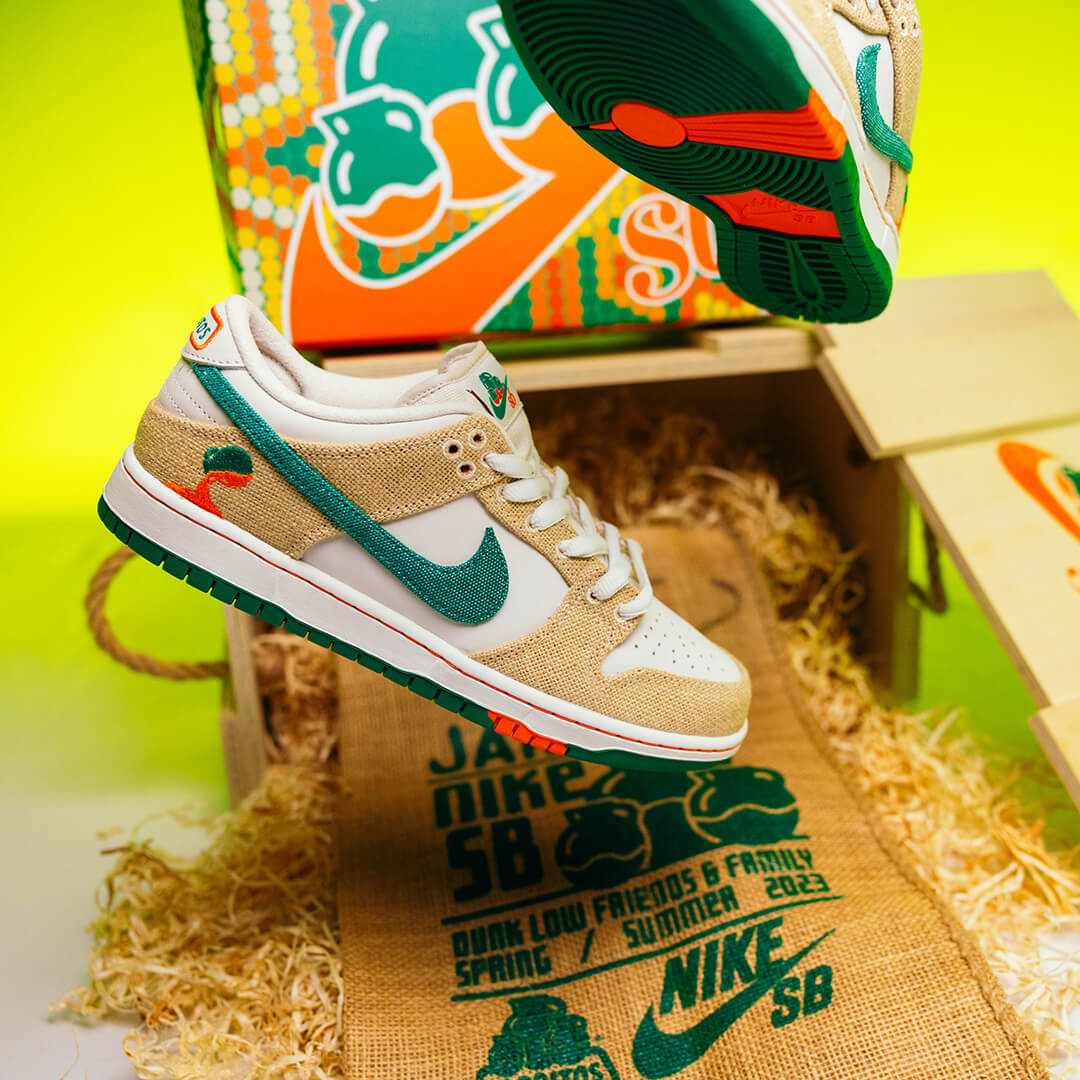 Close-up of the Nike SB Dunk Low sneaker from the Jarritos collaboration, featuring burlap textures, green swoosh, orange accents, and soda bottle embroidery—displayed with custom packaging and branding celebrating the Spring/Summer 2023 limited-edition release.